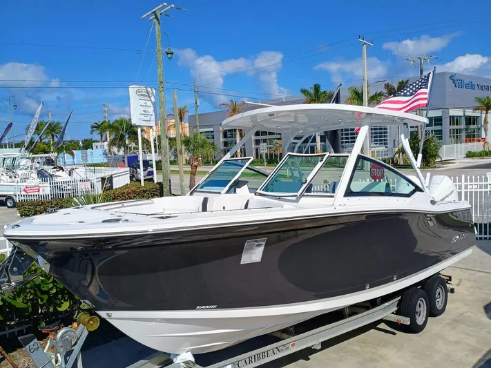 272-292 Yacht Photos Pics 2024 Blackfin 272 DC boat on trailer, displayed outdoors under clear blue sky.