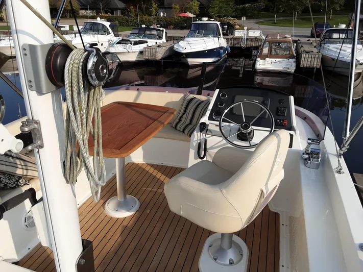  Yacht Photos Pics 2014 Beneteau Swift Trawler 34 helm with wooden deck, docked at marina.