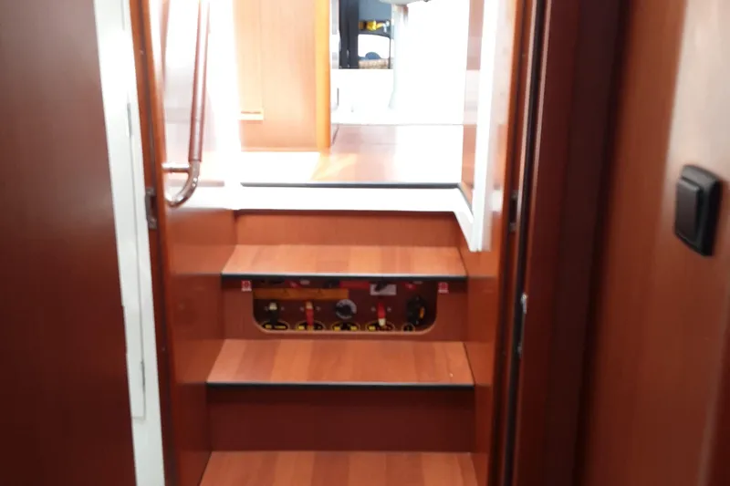  Yacht Photos Pics Interior stairs of 2014 Beneteau Swift Trawler 34, featuring wooden steps and control panel.