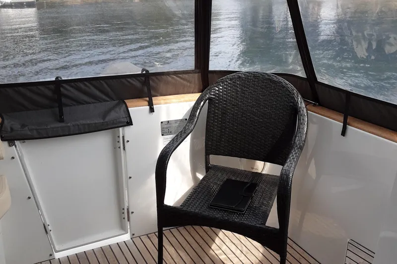  Yacht Photos Pics 2014 Beneteau Swift Trawler 34 cockpit with wicker chair and scenic water view.