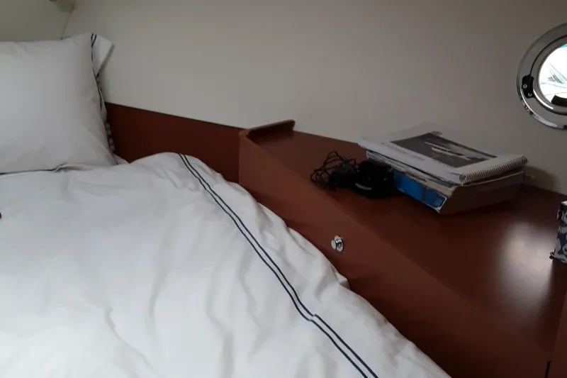  Yacht Photos Pics Cozy cabin interior of 2014 Beneteau Swift Trawler 34 with bed and porthole.