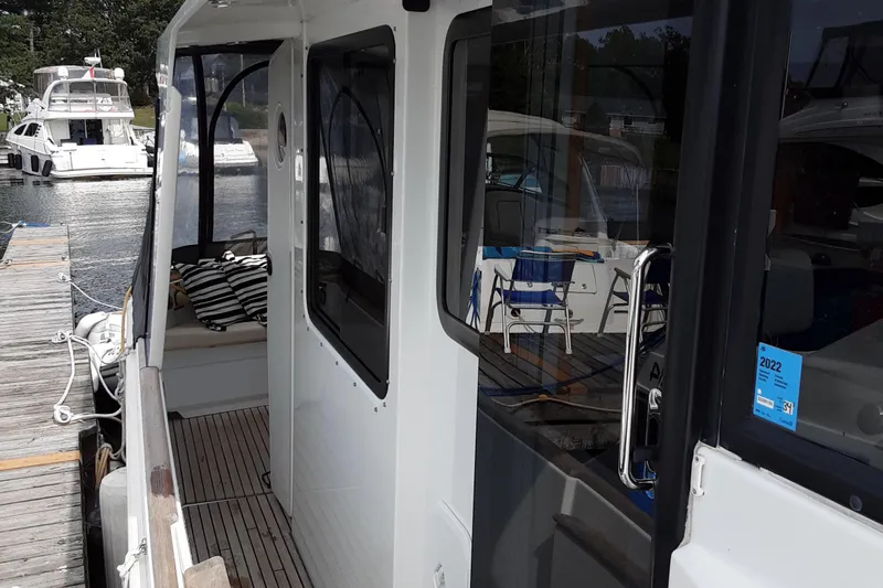  Yacht Photos Pics 2014 Beneteau Swift Trawler 34 docked, showcasing side deck and cabin entrance.