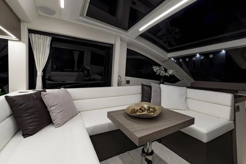 Dream Yacht Photos Pics Manufacturer Provided Image: Modern interior of 2019 Galeon 470 Sky yacht with white seating and wooden table.