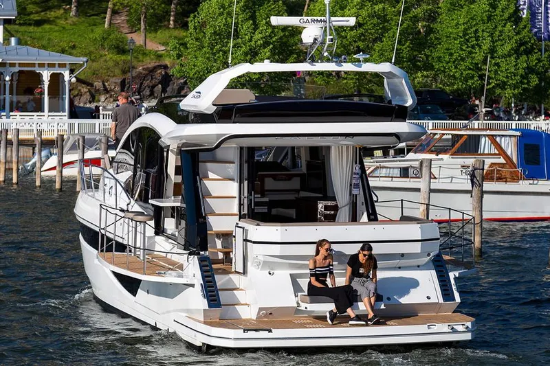 Dream Yacht Photos Pics Manufacturer Provided Image: 2019 Galeon 470 Sky yacht docked with two people sitting on the stern.