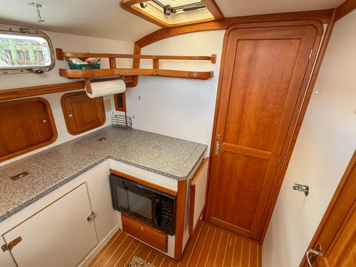 Waypoint Yacht Photos Pics Legacy 34 Express 2002 boat interior with wooden cabinetry and compact kitchen area.