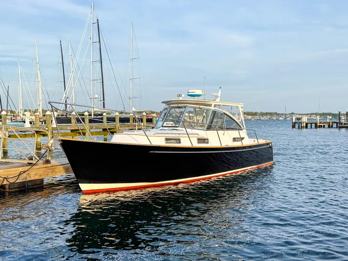 Waypoint Yacht Photos Pics 2002 Legacy 34 Express boat docked in a marina, calm water, clear sky.