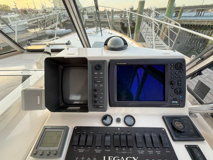 Waypoint Yacht Photos Pics 2002 Legacy 34 Express boat dashboard with navigation equipment and controls at a marina.