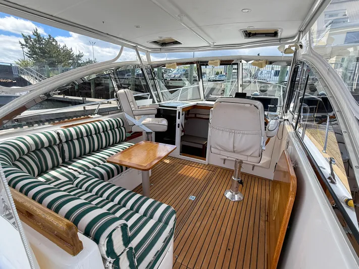 Waypoint Yacht Photos Pics 2002 Legacy 34 Express yacht interior with striped seating and wooden flooring.
