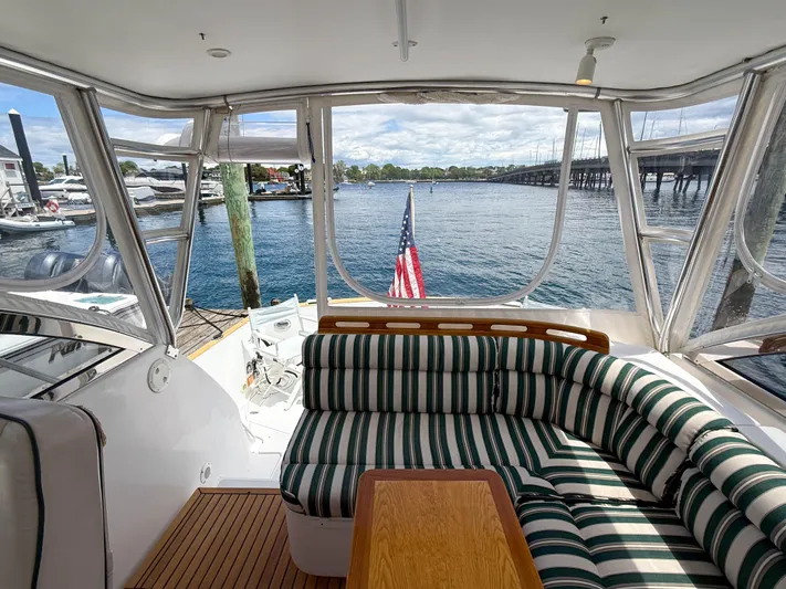 Waypoint Yacht Photos Pics Interior view of 2002 Legacy 34 Express yacht with striped seating and waterfront backdrop.