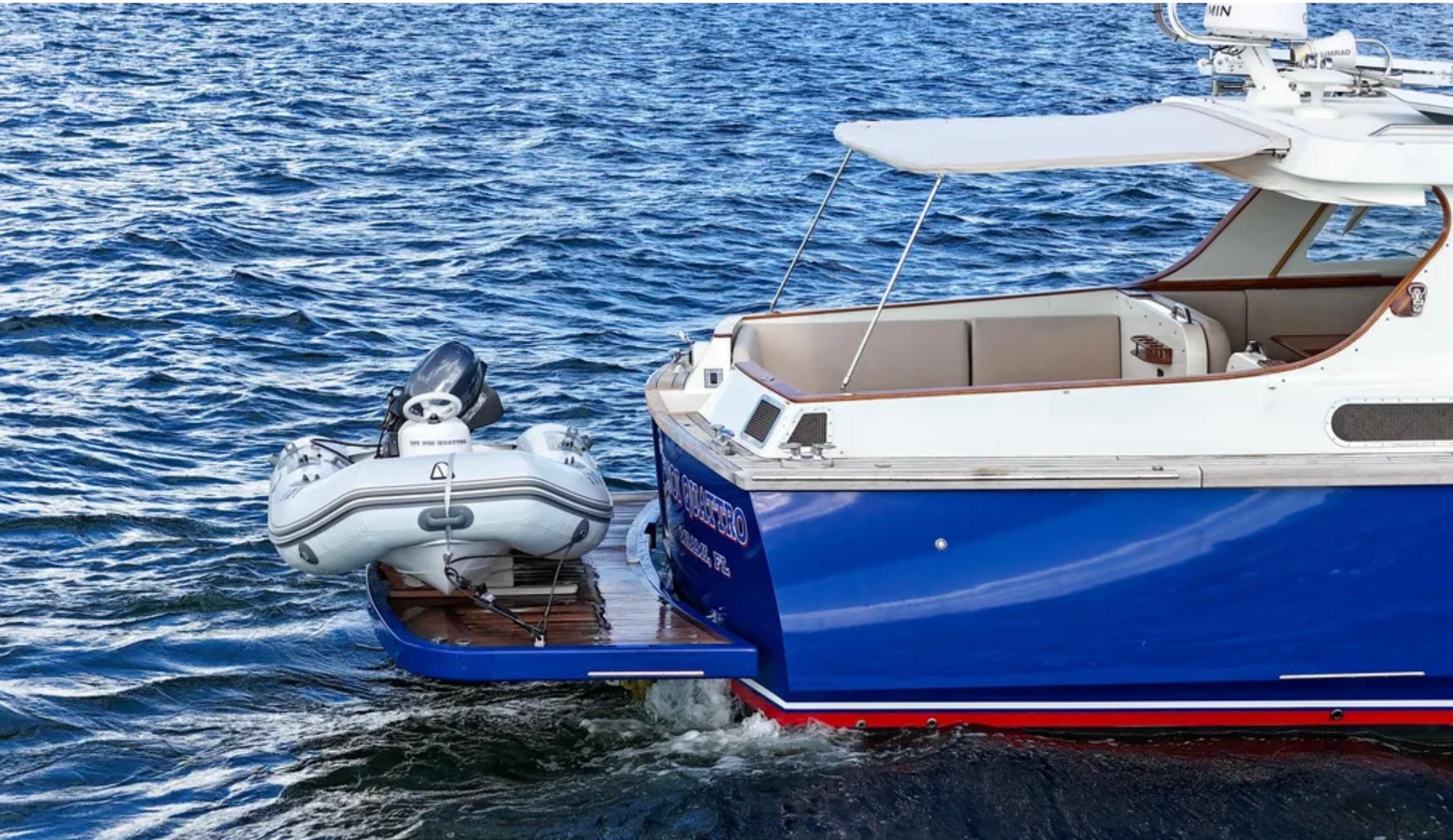 Custom 2010 Gentleman's Motor Yacht with inflatable boat on blue ocean water.