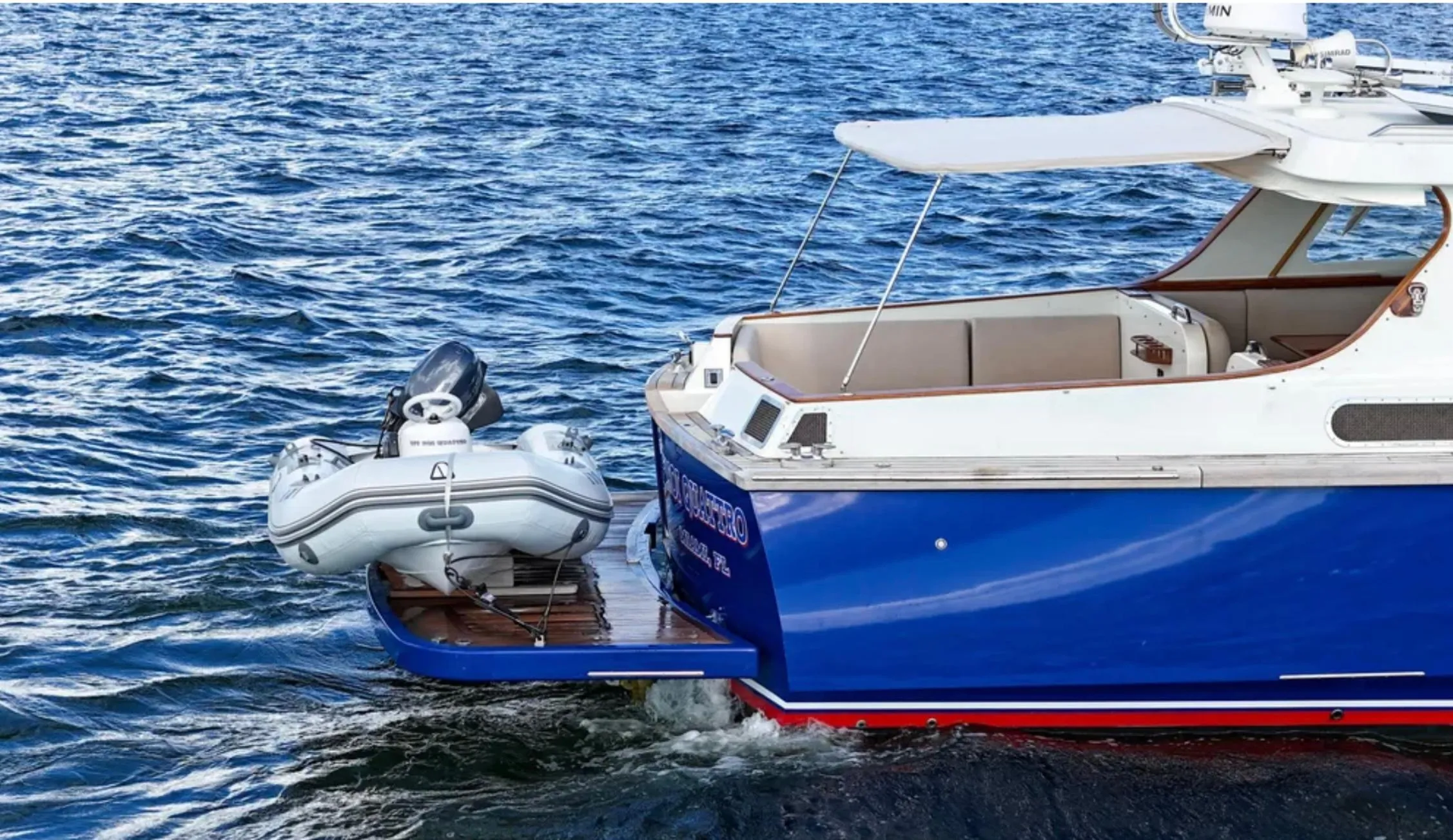 Custom 2010 Gentleman's Motor Yacht with inflatable boat on blue ocean water.