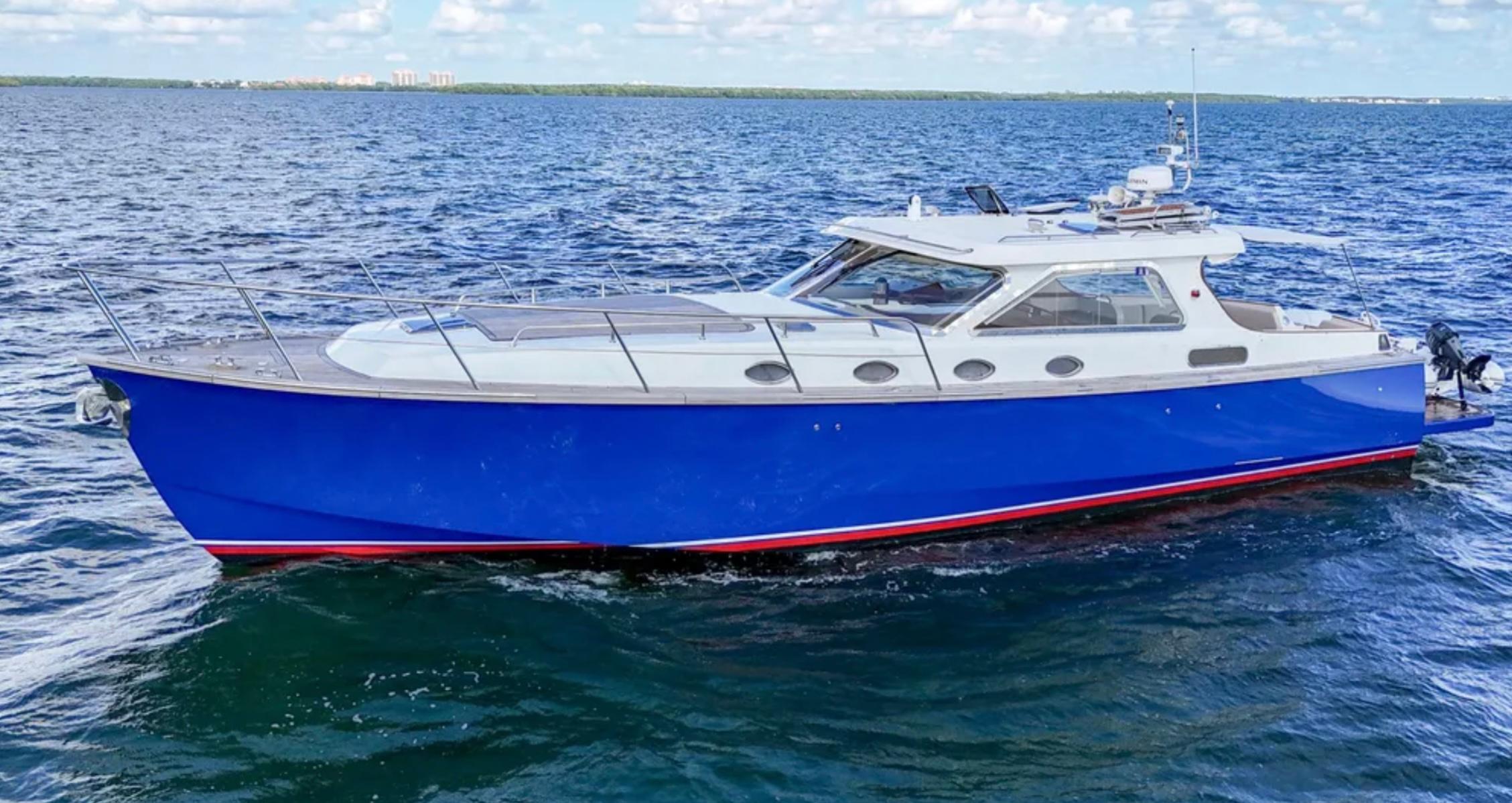 Custom 2010 Gentleman's Motor Yacht with blue hull cruising on open water.