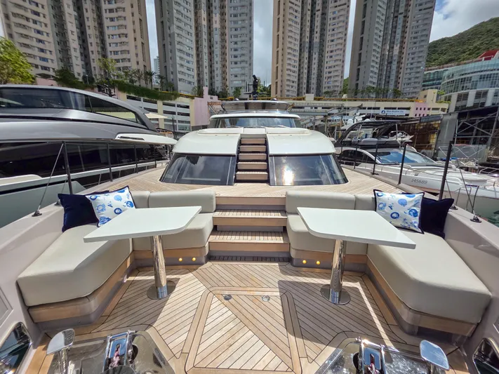  Yacht Photos Pics Luxurious 2025 Sanlorenzo SD90 yacht deck with seating, tables, and cityscape backdrop.