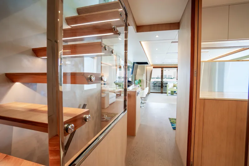 One More Time Yacht Photos Pics Modern interior of 2020 Horizon FD80 yacht with sleek wooden staircase and spacious living area.