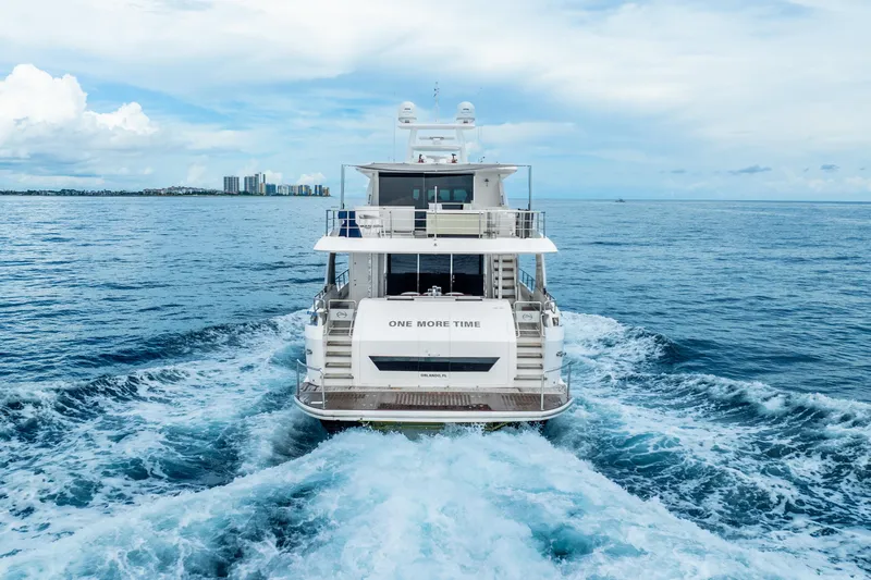One More Time Yacht Photos Pics Luxury Horizon FD80 yacht cruising on open sea, 2020 model, with city skyline in background.