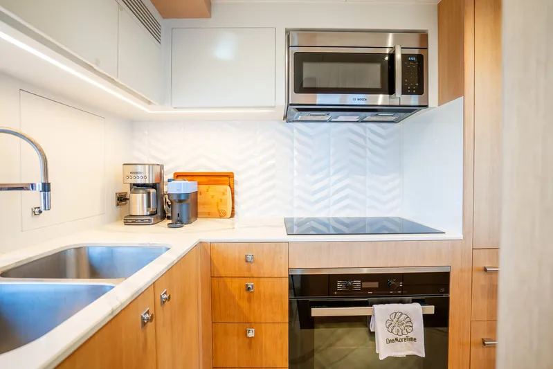 One More Time Yacht Photos Pics Modern kitchen in 2020 Horizon FD80 yacht with sleek appliances and wooden cabinetry.