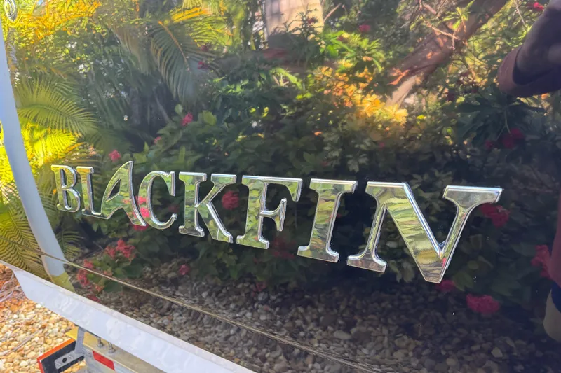  Yacht Photos Pics Blackfin 272 CC 2021 boat logo with lush greenery background.