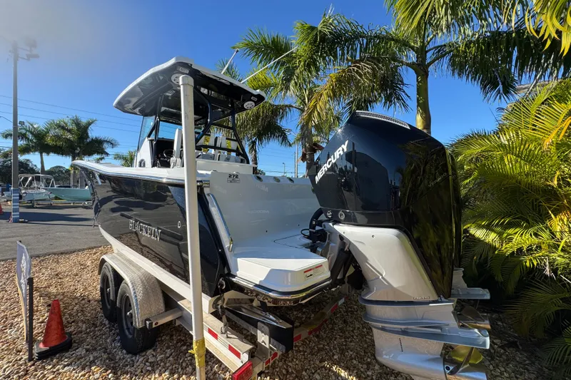  Yacht Photos Pics 2021 Blackfin 272 CC boat on trailer, surrounded by palm trees, with Mercury engine.