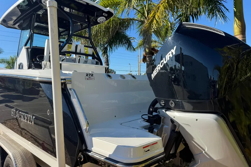  Yacht Photos Pics 2021 Blackfin 272 CC boat with Mercury engine, parked under palm trees.