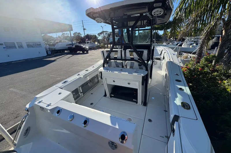  Yacht Photos Pics 2021 Blackfin 272 CC boat interior with seating and console, docked outdoors.
