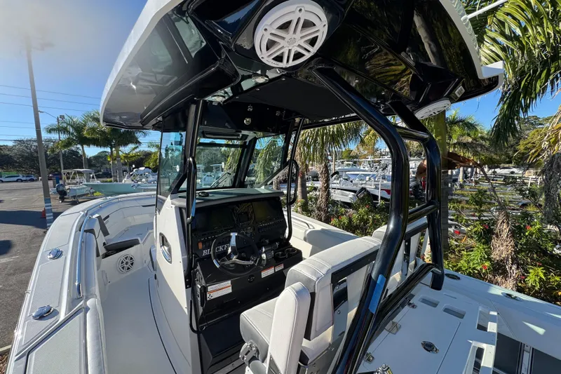  Yacht Photos Pics 2021 Blackfin 272 CC boat interior with helm, seating, and palm trees in the background.