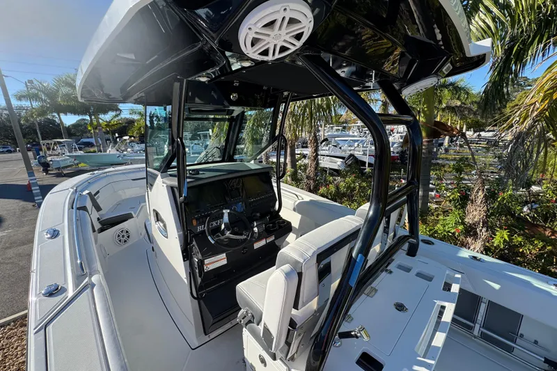 Yacht Photos Pics 2021 Blackfin 272 CC boat interior with helm, seating, and tropical background.