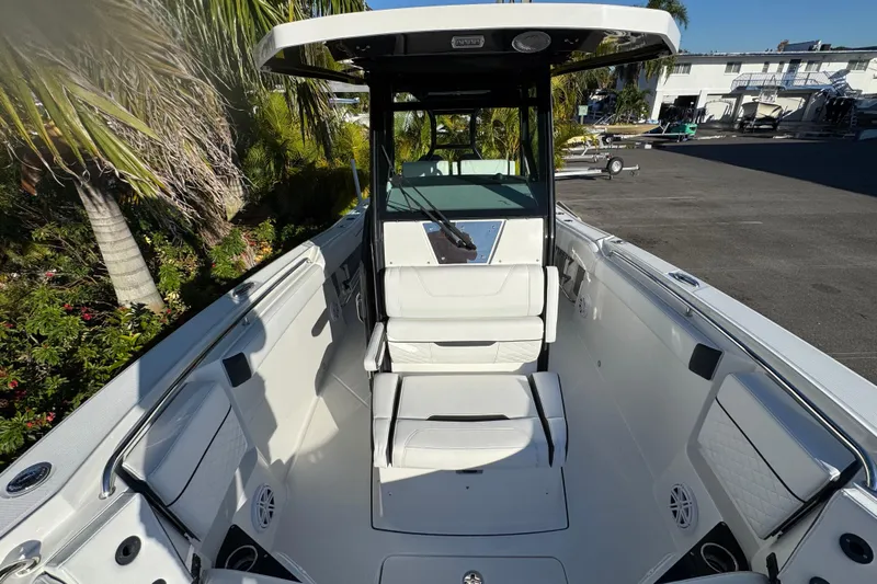  Yacht Photos Pics 2021 Blackfin 272 CC boat interior with seating and console, surrounded by tropical plants.