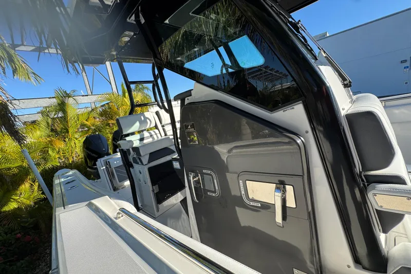  Yacht Photos Pics 2021 Blackfin 272 CC boat interior with seating and control panel, surrounded by tropical plants.