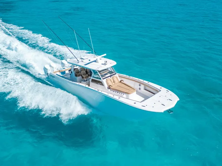  Yacht Photos Pics 2025 Caymas 44 CT boat cruising on clear turquoise water.