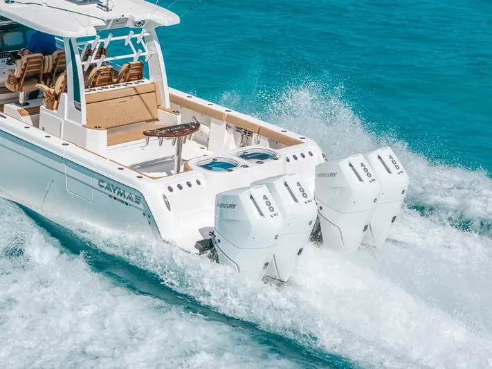  Yacht Photos Pics 2025 Caymas 44 CT boat cruising on clear blue water with powerful engines.