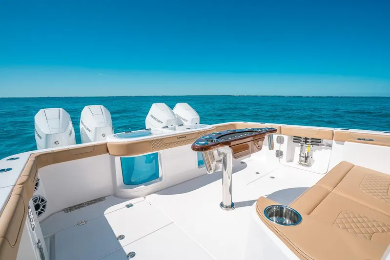  Yacht Photos Pics 2025 Caymas 44 CT boat deck with luxurious seating and multiple engines on a clear blue sea.
