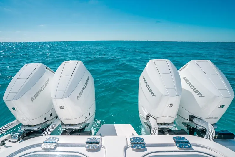  Yacht Photos Pics 2025 Caymas 44 CT boat with four Mercury outboard engines on clear blue water.