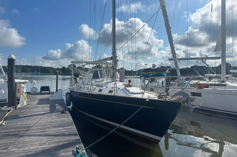  Yacht Photos Pics Sailboat docked at marina, Tayana 48 model, 1995, under a partly cloudy sky.