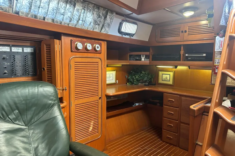  Yacht Photos Pics Interior of 1995 Tayana 48 yacht with wooden cabinetry and green leather chair.