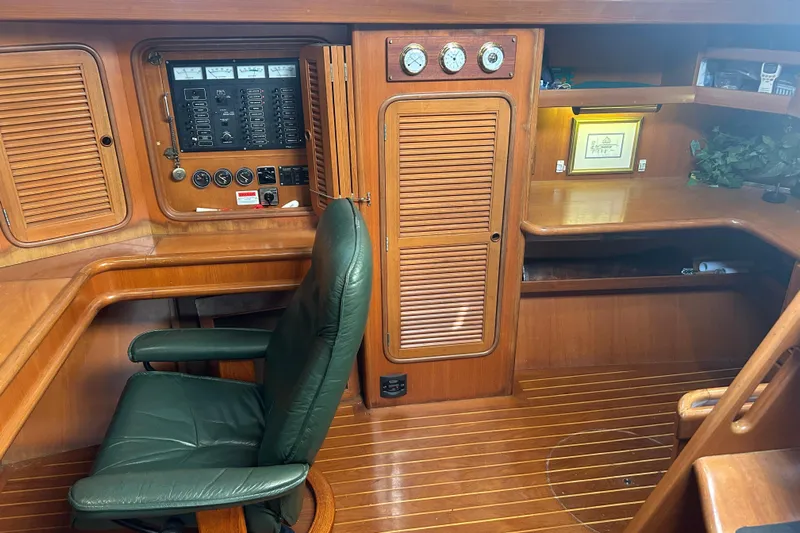  Yacht Photos Pics Interior of 1995 Tayana 48 yacht with wooden cabinetry and green leather chair.