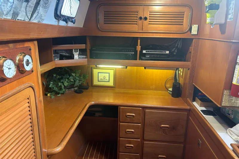  Yacht Photos Pics Cozy wooden interior of 1995 Tayana 48 yacht with desk, cabinets, and nautical decor.