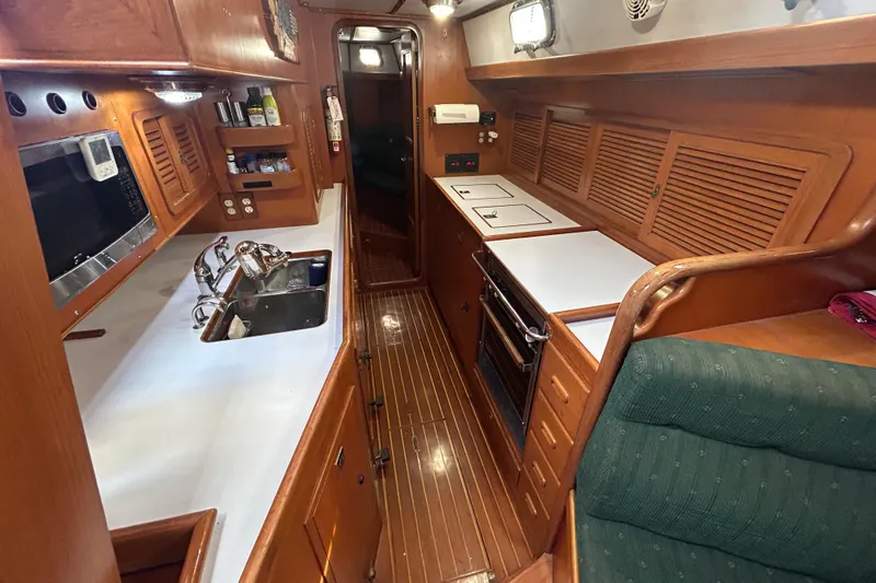  Yacht Photos Pics Interior of 1995 Tayana 48 yacht kitchen with wood finish and modern appliances.