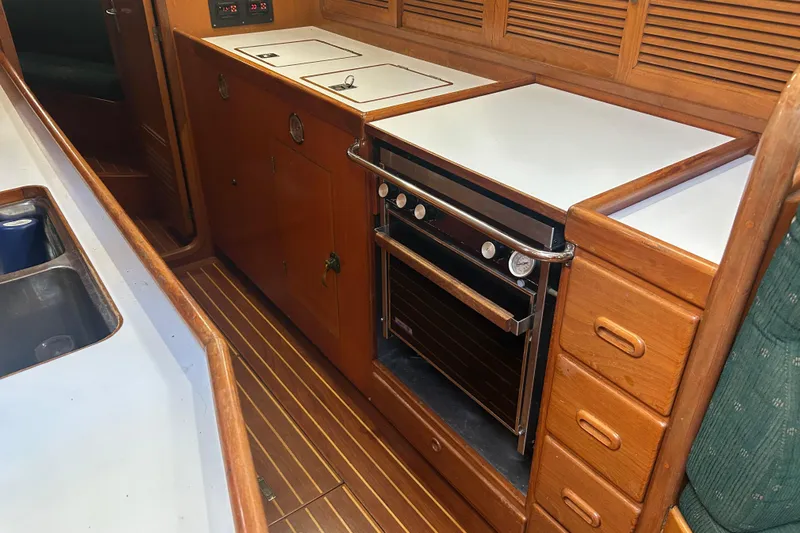  Yacht Photos Pics Interior of 1995 Tayana 48 yacht featuring a wooden galley with stove and storage.