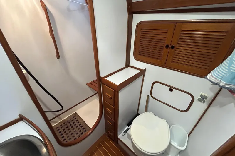  Yacht Photos Pics Bathroom interior of a 1995 Tayana 48 yacht, featuring wooden cabinetry and a shower area.