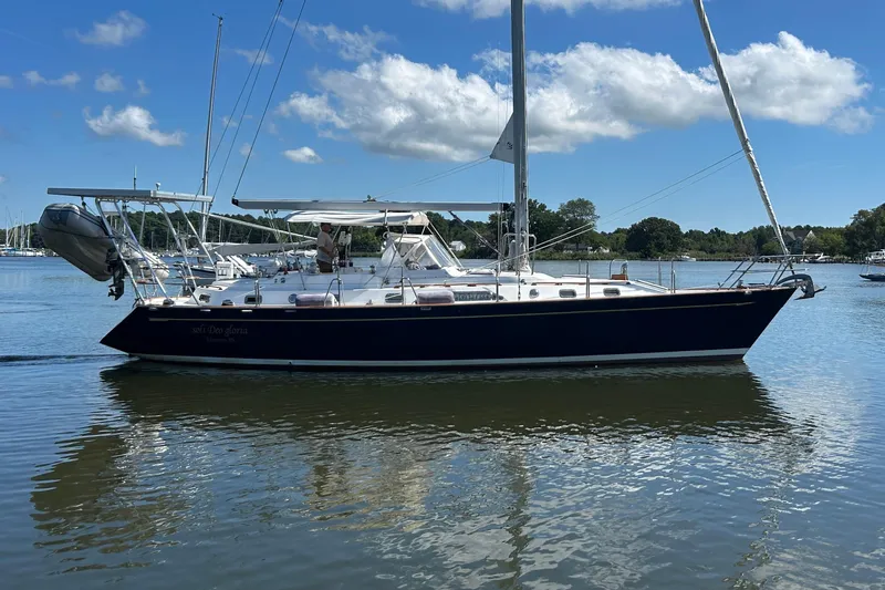  Yacht Photos Pics Sailing yacht Tayana 48, 1995 model, on calm water under a clear blue sky.