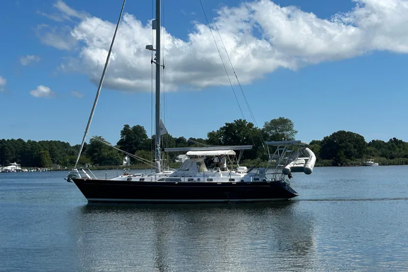  Yacht Photos Pics Sailing yacht Tayana 48, 1995 model, cruising on a calm lake under a clear blue sky.