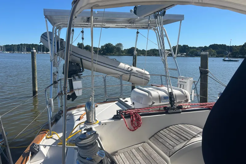  Yacht Photos Pics Sailboat deck view of 1995 Tayana 48, featuring lifeboat and calm marina backdrop.