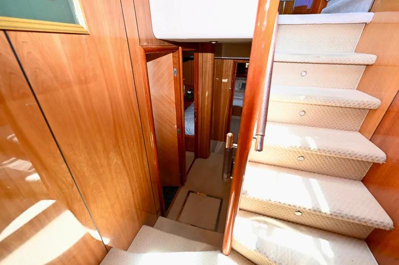 "bella" Yacht Photos Pics Interior staircase of 2005 Sunseeker 82 Yacht with wooden paneling and carpeted steps.