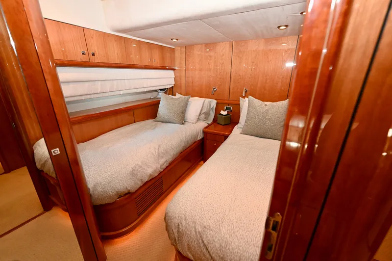 "bella" Yacht Photos Pics Luxurious twin bedroom on 2005 Sunseeker 82 Yacht with wooden finishes and cozy bedding.