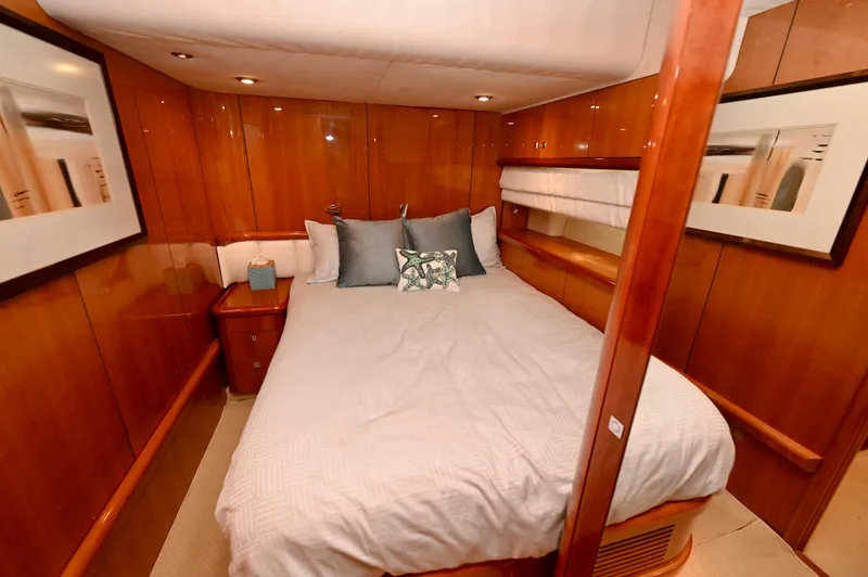 "bella" Yacht Photos Pics Luxurious cabin interior of a 2005 Sunseeker 82 Yacht with wood paneling and cozy bedding.