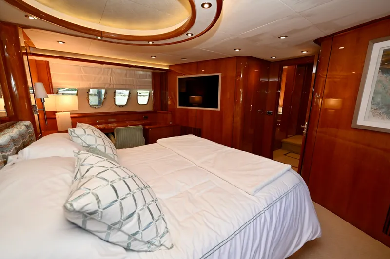 "bella" Yacht Photos Pics Luxurious bedroom interior of 2005 Sunseeker 82 Yacht with elegant wood paneling and modern amenities.