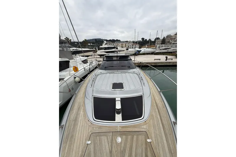  Yacht Photos Pics 2024 Riva 56 RIVALE yacht docked at a marina, showcasing sleek design and luxury.