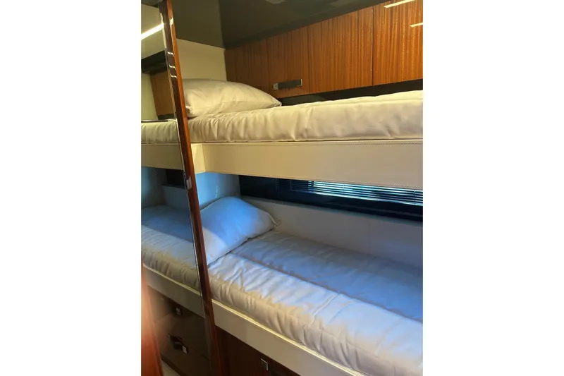  Yacht Photos Pics Bunk beds in 2024 Riva 56 RIVALE yacht cabin, featuring wooden cabinetry.