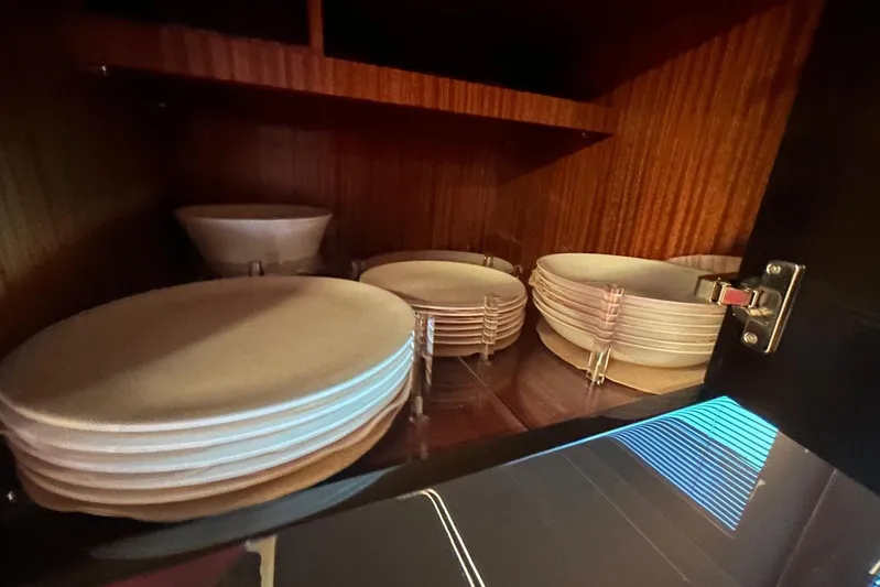  Yacht Photos Pics Cabinet with neatly stacked white plates on a 2024 Riva 56 Rivale yacht.