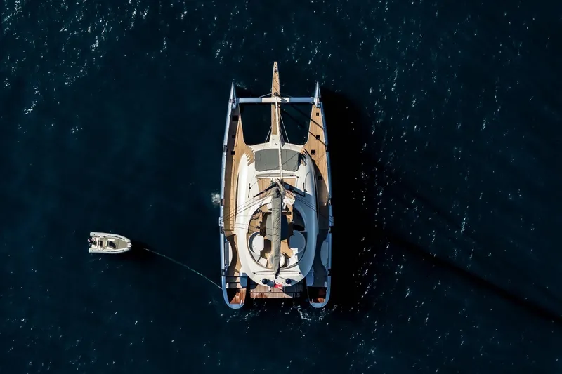 Lyfe At Sea Yacht Photos Pics Aerial view of 2015 Magic Yachts Custom catamaran on dark blue water.